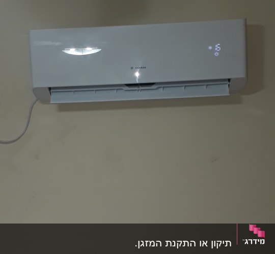 מזגן קיר לבן עם תצוגת טמפרטורה דיגיטלית